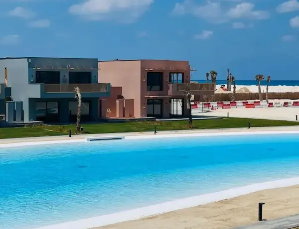 بحر ورمال ومباني داخل بلايا في رأس الحكمة من مشاريع نيو جيزة الساحل الشمالي